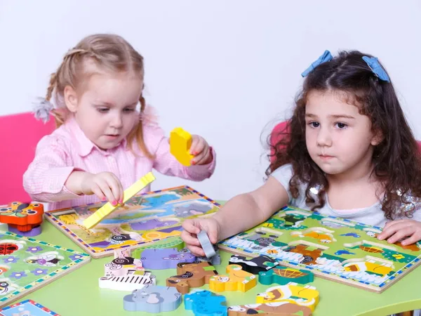 Две девочки играют в настольную игру